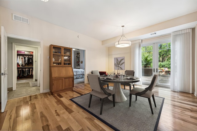 dining area featuring light wood-type flooring and french doors