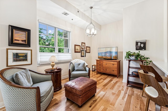 living area featuring wood-type flooring and a notable chandelier