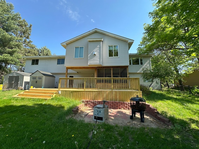 1028 241st Ave NE, East Bethel, MN 55005 - back of property with a yard, a wooden deck, a sunroom, and an outdoor fire pit