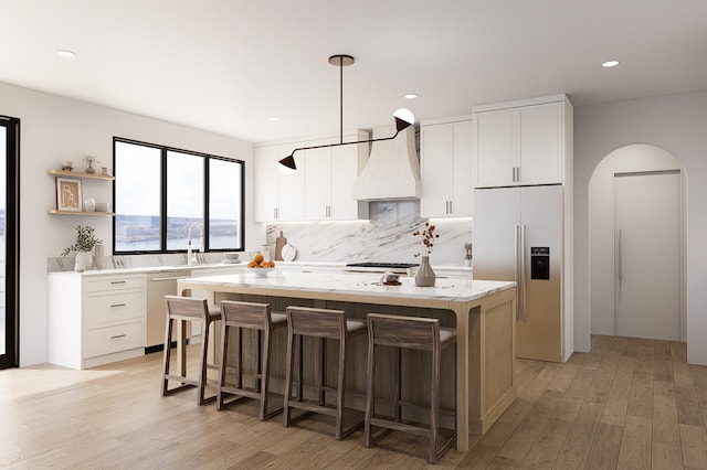 kitchen featuring white cabinetry, premium range hood, appliances with stainless steel finishes, and a center island