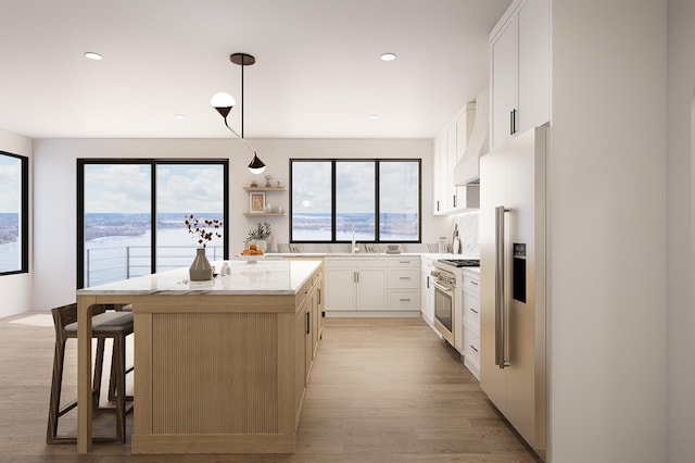 kitchen with white cabinetry, a center island, high end appliances, and hanging light fixtures