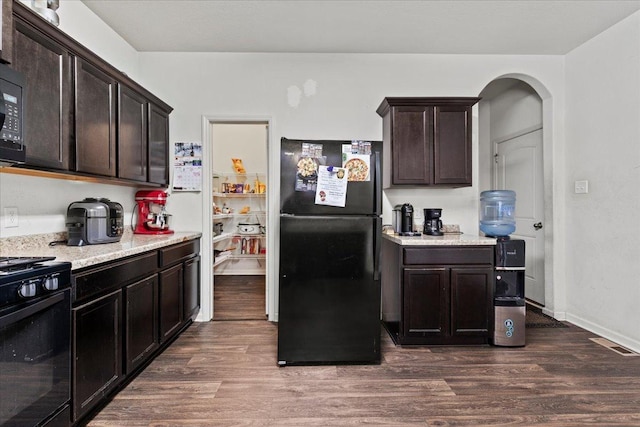 kitchen with dark wood-type flooring, dark brown cabinetry, and black appliances