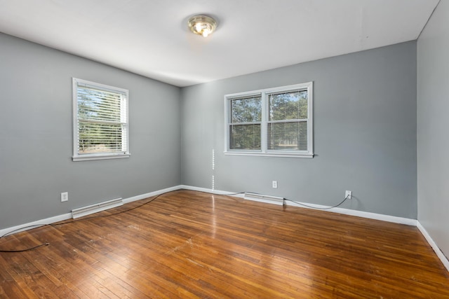 empty room with visible vents, baseboards, and hardwood / wood-style floors