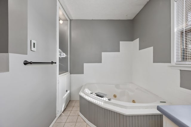 bathroom featuring a textured ceiling, a jetted tub, vanity, and tile patterned flooring