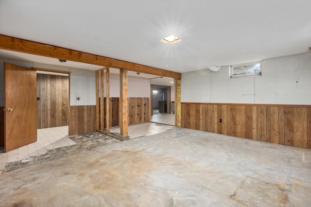 finished below grade area featuring wooden walls and a wainscoted wall