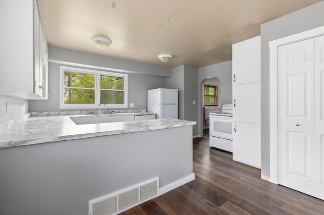 13749 County Road 116, Merrifield, MN 56465 - kitchen featuring white appliances, a peninsula, white cabinets, arched walkways, and dark wood-style floors