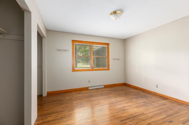 13749 County Road 116, Merrifield, MN 56465 - unfurnished bedroom with baseboard heating, wood finished floors, baseboards, and a closet