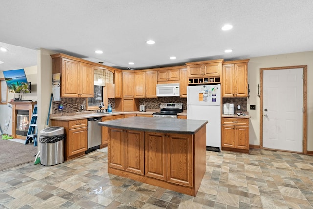 kitchen with backsplash, a center island, sink, and appliances with stainless steel finishes