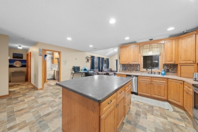 kitchen featuring decorative backsplash, sink, a kitchen island, and appliances with stainless steel finishes