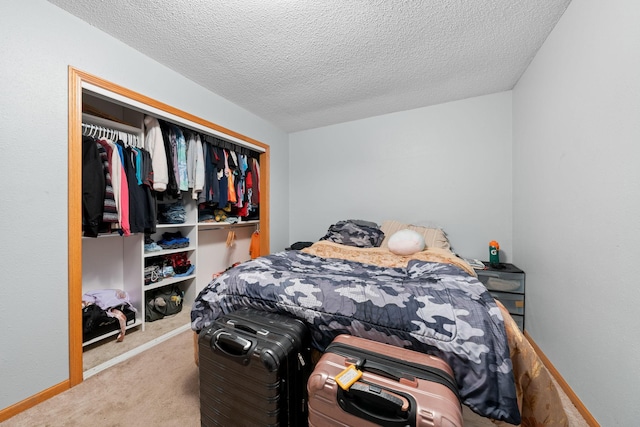 carpeted bedroom featuring a textured ceiling and a closet