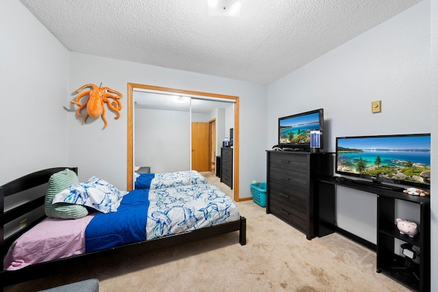 bedroom featuring a textured ceiling, light carpet, and a closet