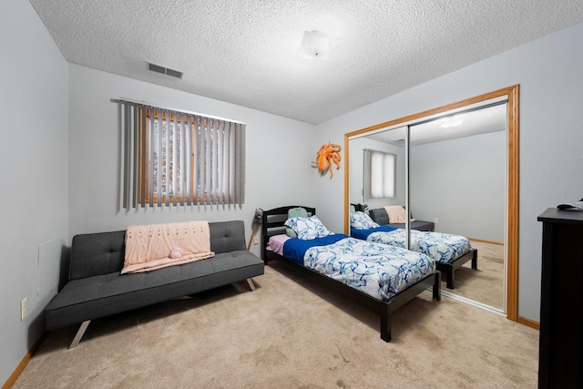 bedroom with light carpet, a closet, and a textured ceiling