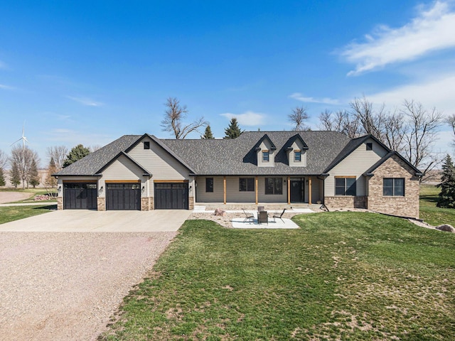 view of front of property with a front yard, a patio, a fire pit, and a garage