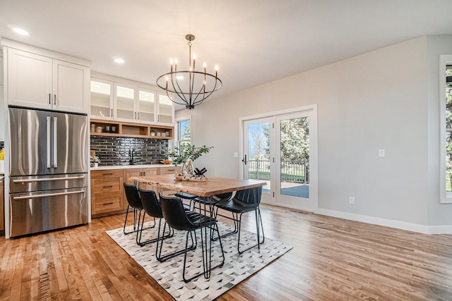 dining area featuring light hardwood / wood-style floors, sink, and a chandelier