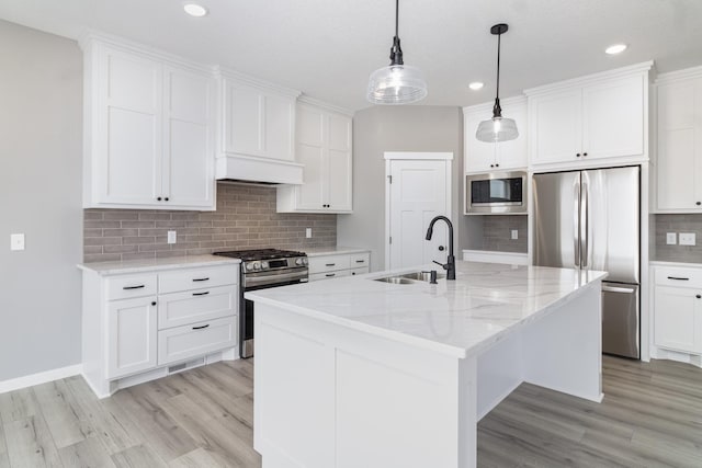 kitchen featuring white cabinetry, sink, a center island with sink, and appliances with stainless steel finishes