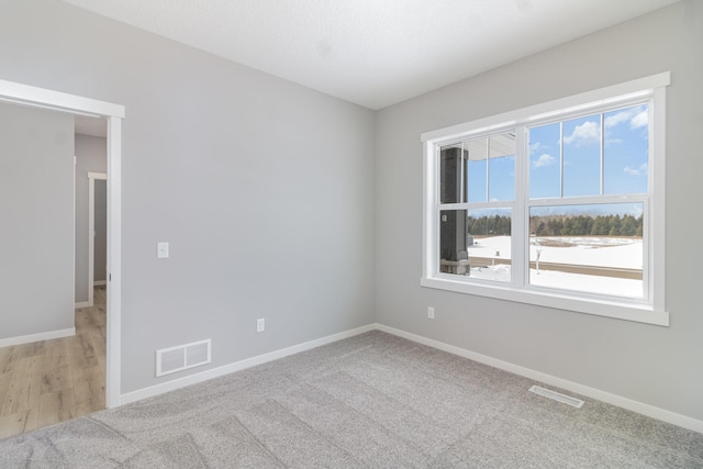 unfurnished room featuring light carpet