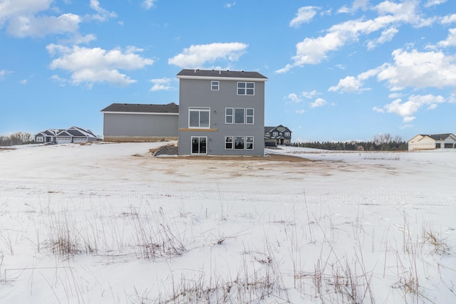 view of snow covered rear of property