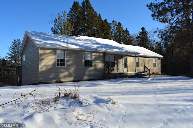 view of snow covered rear of property