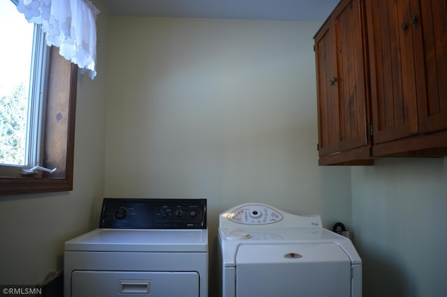 laundry area with washer and dryer and cabinets