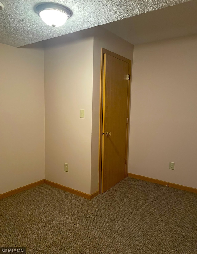 carpeted empty room with a textured ceiling