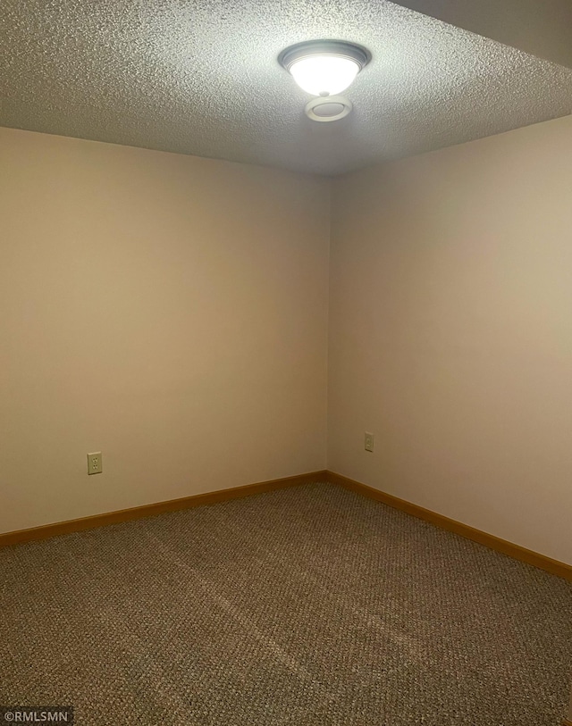 spare room featuring carpet and a textured ceiling