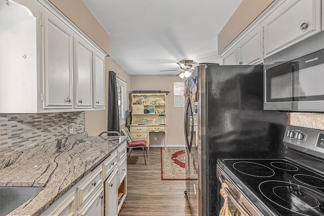 kitchen featuring light stone countertops, backsplash, black electric range oven, ceiling fan, and white cabinetry