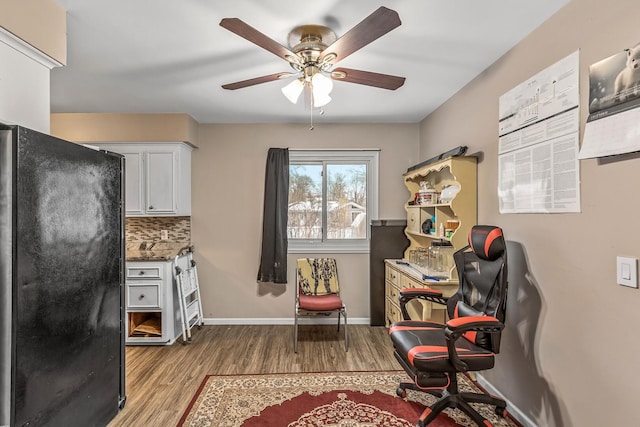 sitting room with ceiling fan and light wood-type flooring