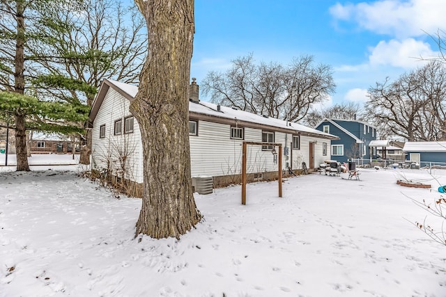 snow covered back of property featuring cooling unit