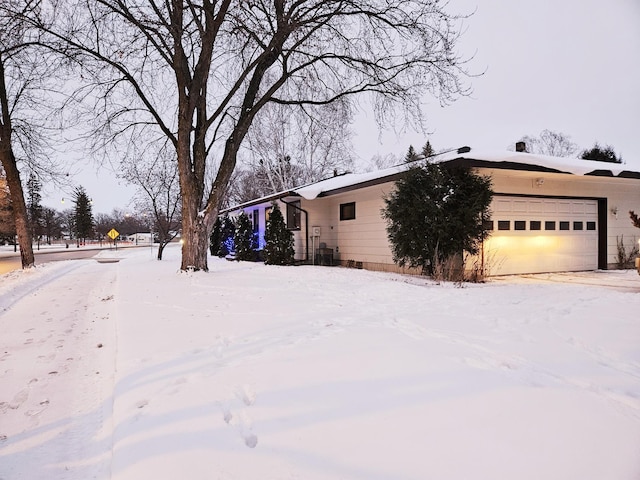 yard covered in snow featuring a garage