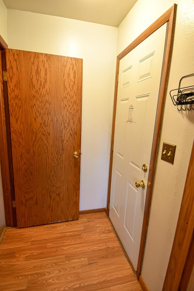 corridor with light hardwood / wood-style flooring