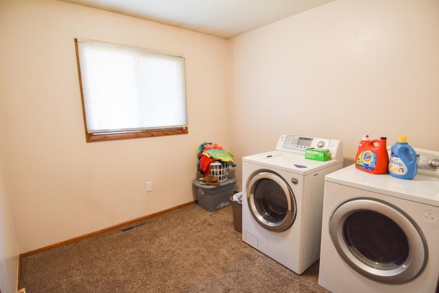 clothes washing area with light carpet and washing machine and clothes dryer