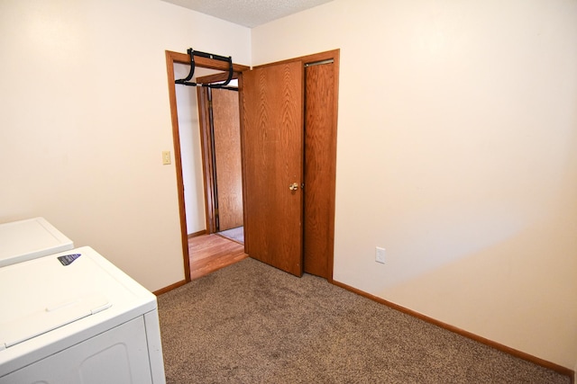 washroom featuring washer / dryer, light colored carpet, and a textured ceiling