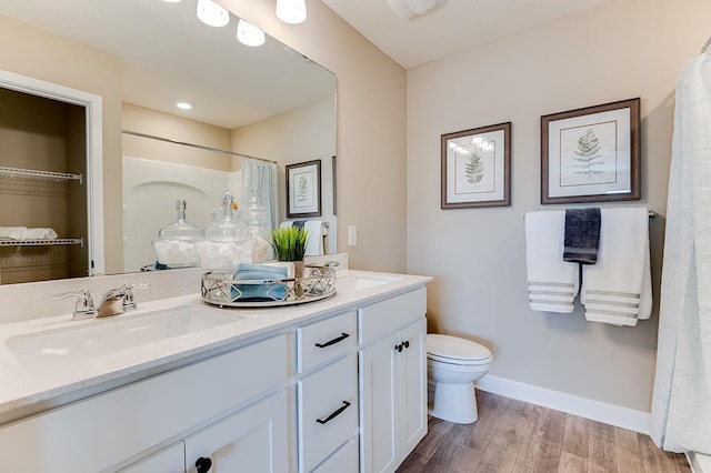 bathroom with hardwood / wood-style floors, vanity, a shower with shower curtain, and toilet