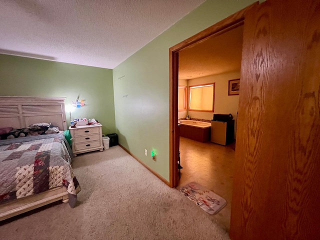 carpeted bedroom featuring a textured ceiling and ensuite bath