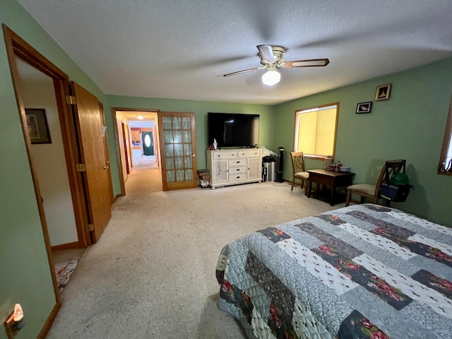 carpeted bedroom with french doors, a textured ceiling, and ceiling fan