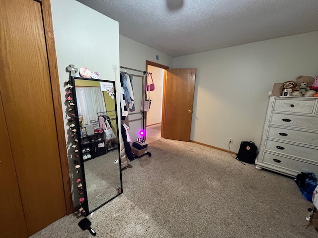 workout area featuring light colored carpet and a textured ceiling