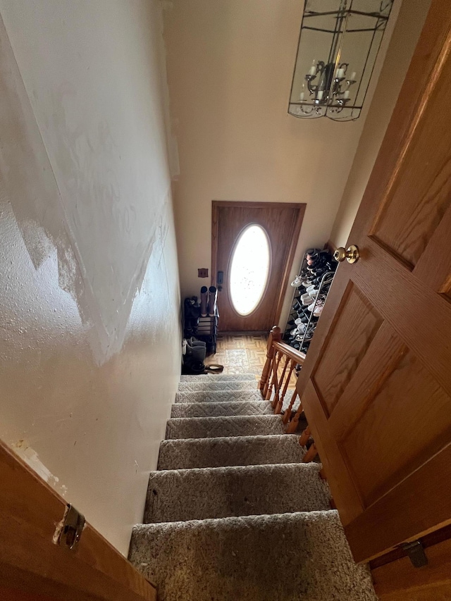 staircase featuring a notable chandelier