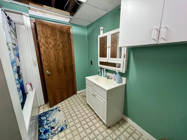 bathroom featuring a drop ceiling, vanity, and shower / bath combination with curtain