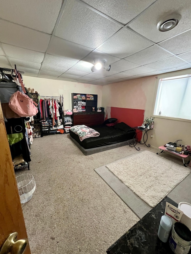 carpeted bedroom featuring a drop ceiling