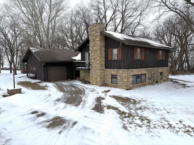 5114 46th St, Merton Twp, MN 55060 - view of property exterior with board and batten siding, a chimney, an attached garage, and stone siding
