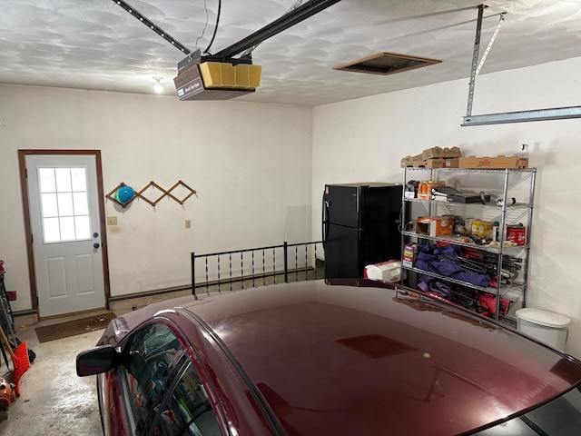 5114 46th St, Merton Twp, MN 55060 - garage featuring a garage door opener and freestanding refrigerator