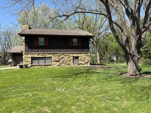 5114 46th St, Merton Twp, MN 55060 - view of side of property featuring a chimney, a yard, board and batten siding, and stone siding