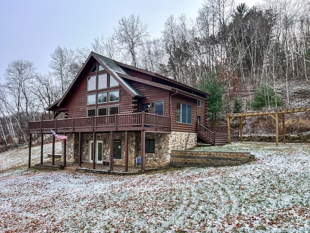 snow covered back of property with a deck