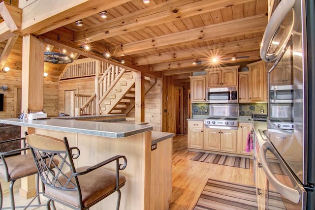 kitchen with wooden ceiling, beamed ceiling, stainless steel appliances, and wooden walls