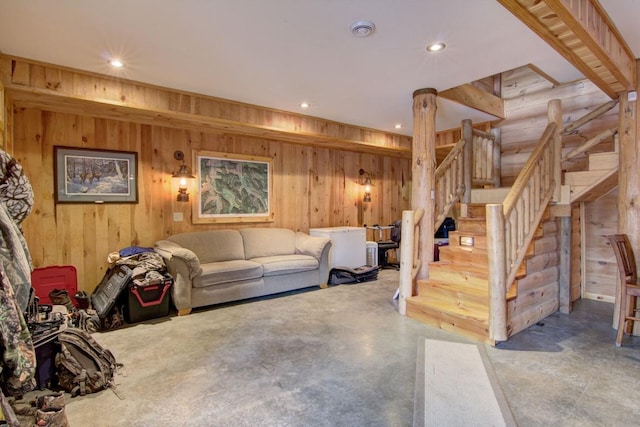 living room featuring wooden walls and concrete floors