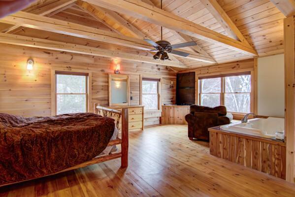 bedroom with lofted ceiling with beams, light hardwood / wood-style flooring, and wood ceiling