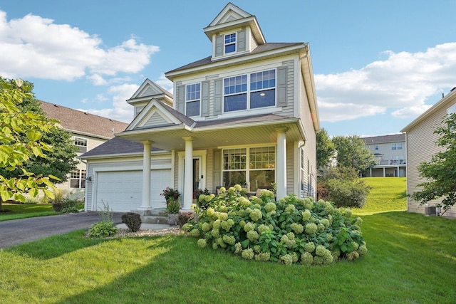 view of front of home with covered porch, a garage, and a front lawn