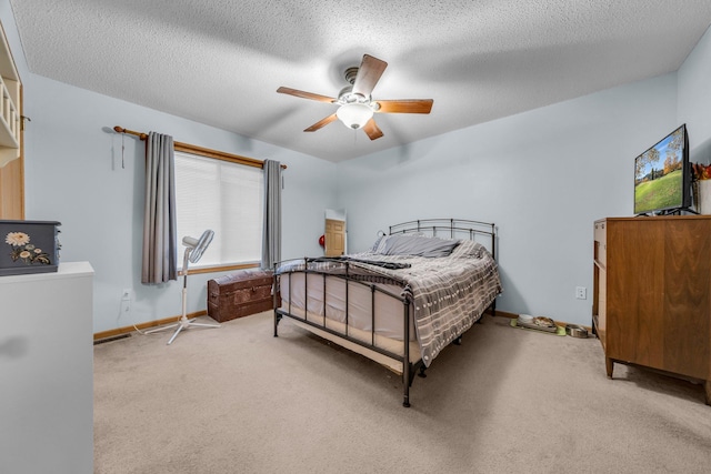 bedroom featuring light carpet, a textured ceiling, and ceiling fan