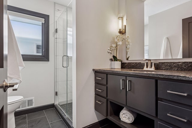 bathroom featuring vanity, toilet, tile patterned floors, and walk in shower