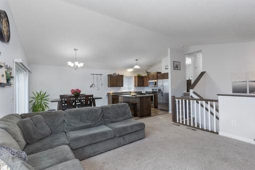 living room with light colored carpet, lofted ceiling, and an inviting chandelier